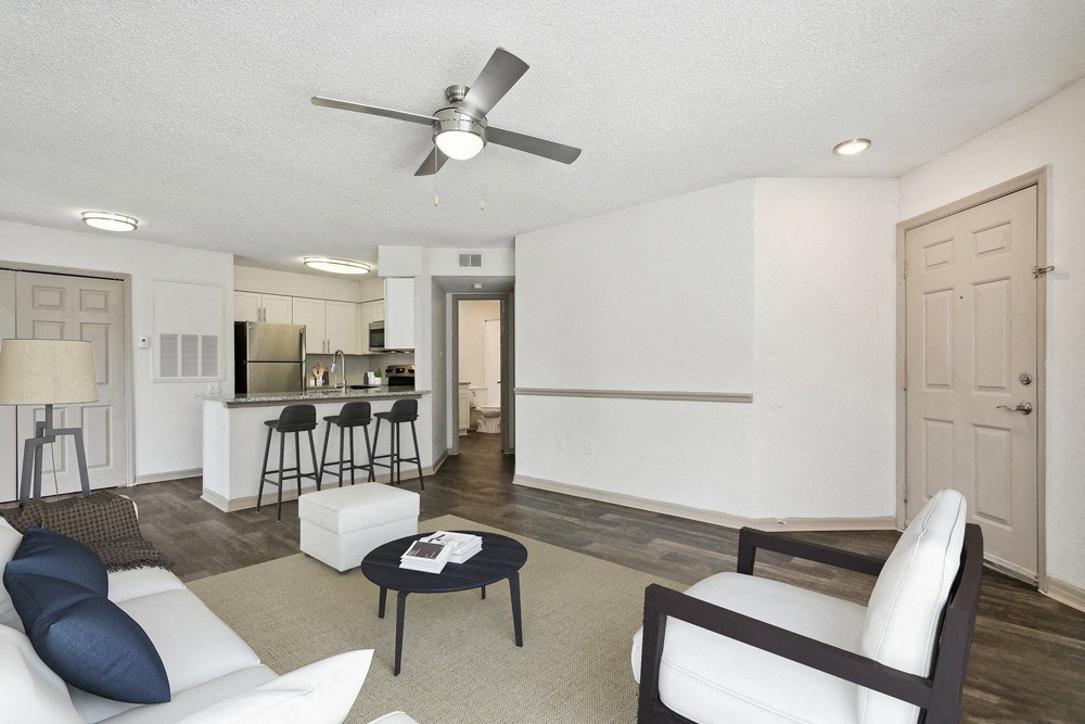 Model living room with white couch and chair at Retreat at Crosstown Apartments