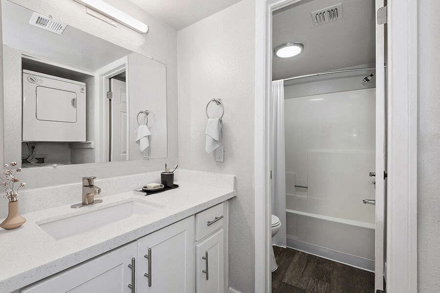 Model Bathroom with White Cabinets, Wood-Style Flooring & Shower/Tub at Crystal Creek Apartments in Phoenix, AZ.