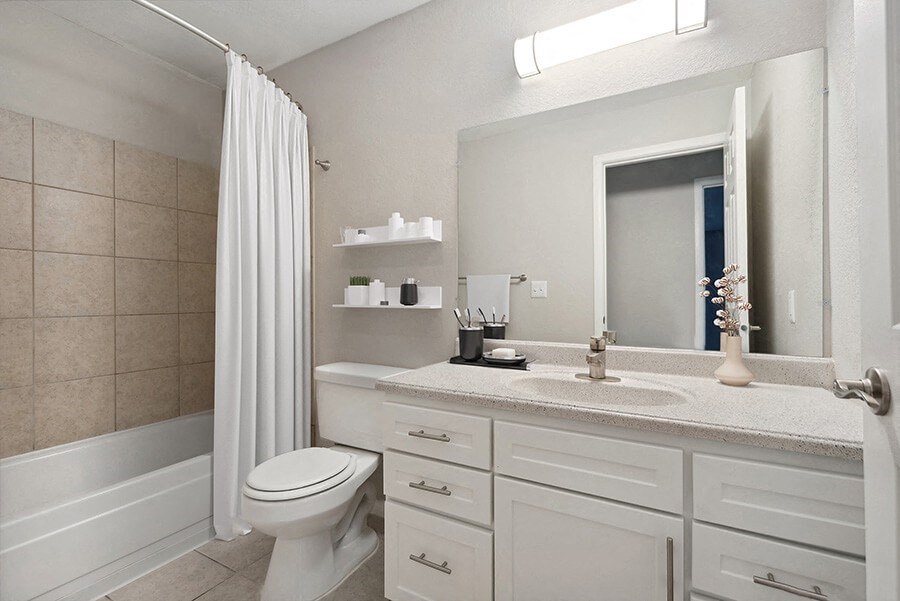 Model Bathroom with White Cabinets and Tile Flooring at Liberty Creek Apartments in Aurora, CO.