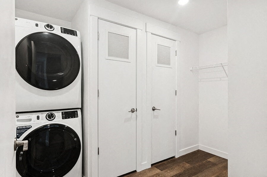 a washer and dryer in a white laundry room with white closets