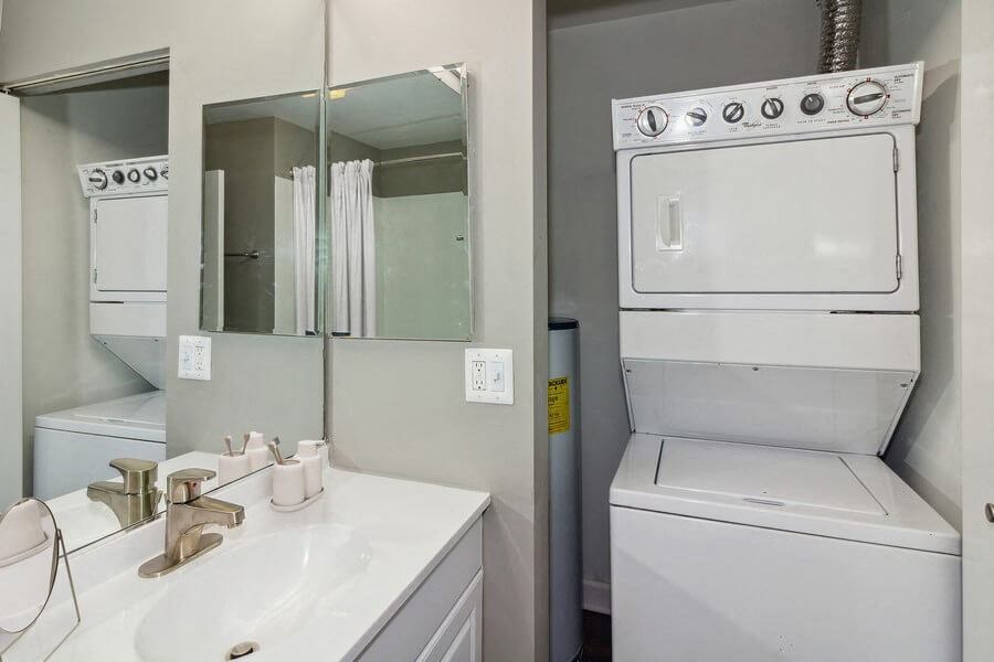 In-home washer/dryer stacked on top of each other in model apartment unit.