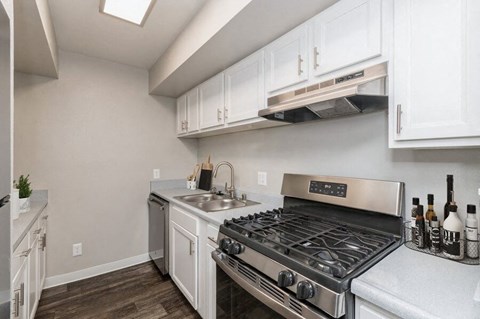 a kitchen with white cabinets and a stove and a sink