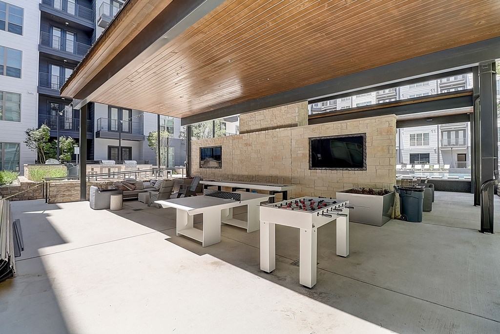 a patio with tables and chairs and a flat screen tv