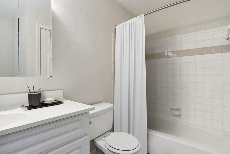 Model Bathroom with White Cabinets and Wood-Style Flooring at The Commons at Haynes Farm Apartments in Boston, MA.