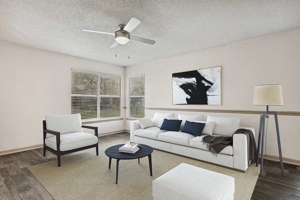Model living room with a white couch and a black coffee table at Retreat at Crosstown Apartments