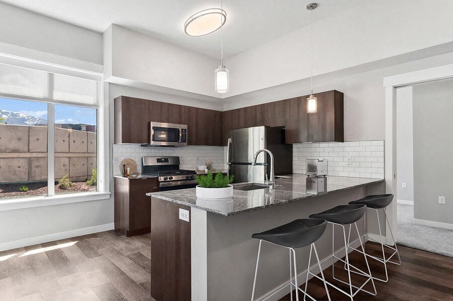 Model Kitchen with Wood-Style Flooring & Dark Oak Cabinets at Seven Skies Apartments located in Sandy, UT.