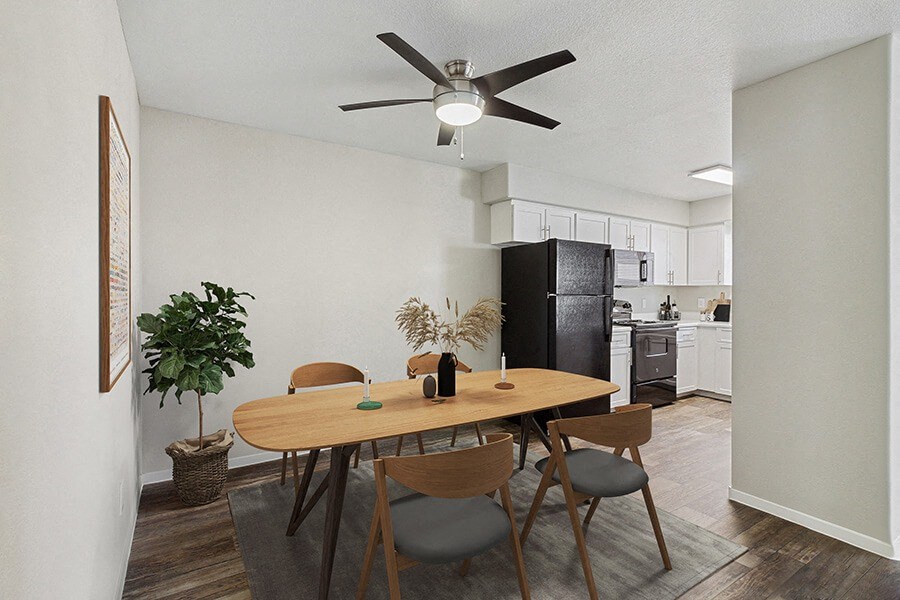 Model Dining Room with Wood-Style Flooring & View of Kitchen at Verraso Apartments in Las Vegas, NV.