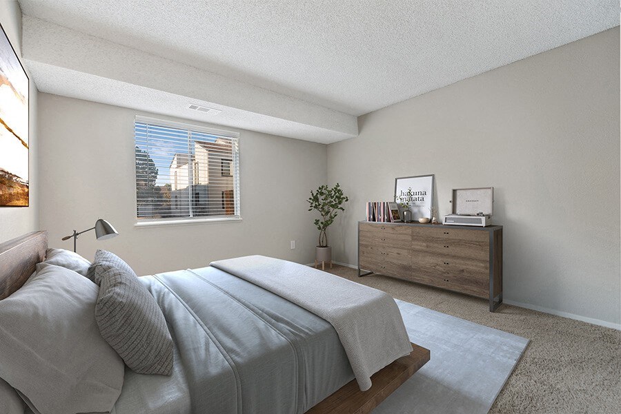 Model Bedroom with Carpet and Window View at Liberty Creek Apartments in Aurora, CO.