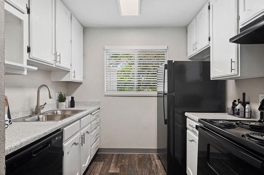 Model Kitchen with White Cabinets and Wood-Style Flooring at Monaco Apartments in Salt Lake City, UT.