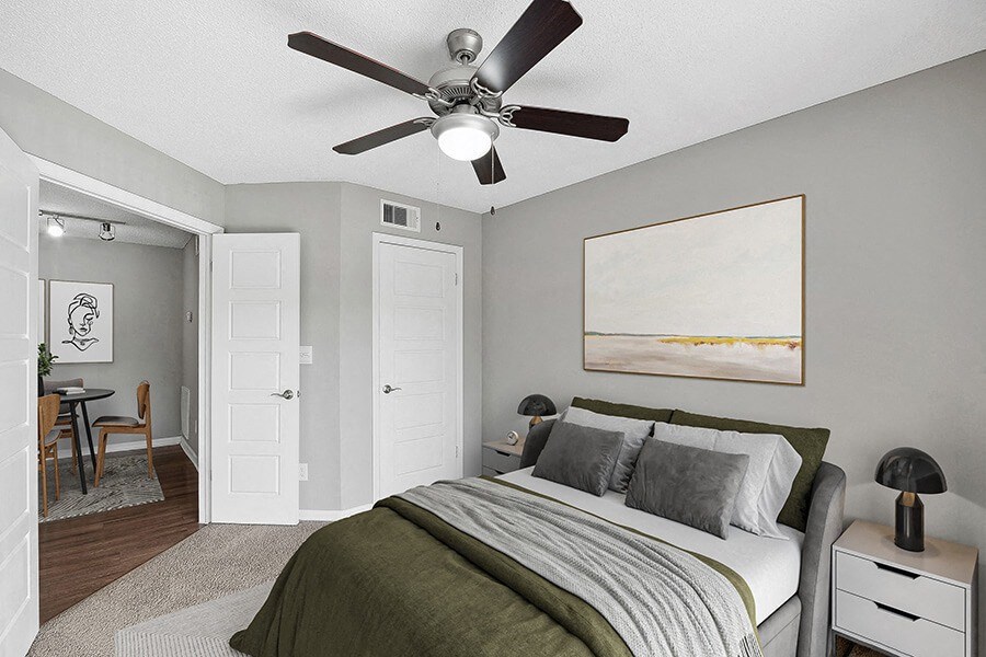 Model Bedroom with Carpet and View of Dining Room Area at Fountains Lee Vista Apartments in Orlando, FL.