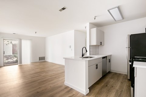 A kitchen with white cabinets and a black fridge.