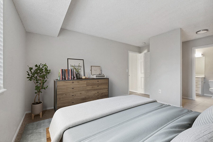 Model Bedroom with Carpet and attached Bathroom at Liberty Creek Apartments in Aurora, CO.