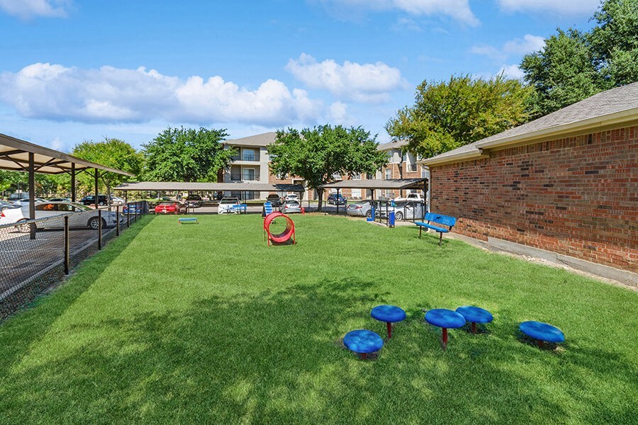 Community Dog Park with Agility Equipment at Belmont at Duck Creek Apartments in Garland, TX.