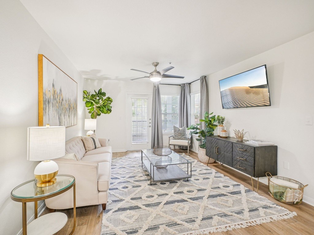 A living room with a glass coffee table and a white sofa.