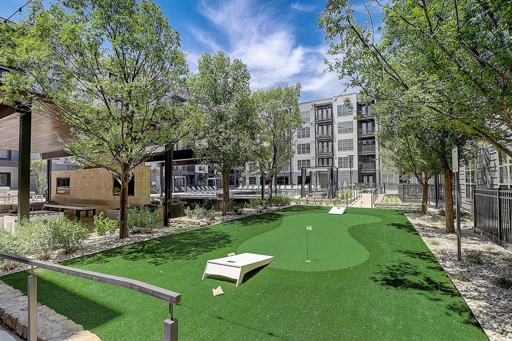 a putting green in a courtyard with a building in the background