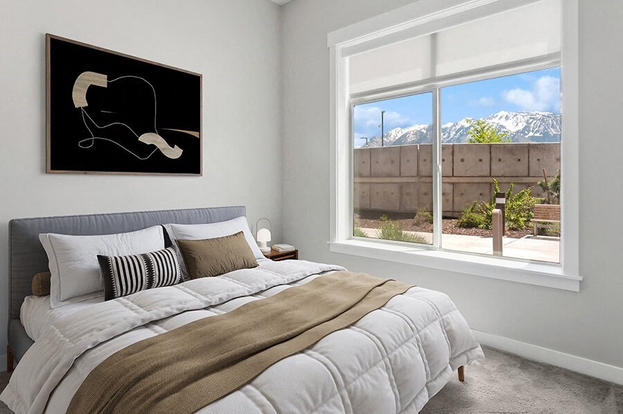 Model Bedroom with Carpet and Window View at Seven Skies Apartments located in Sandy, UT.