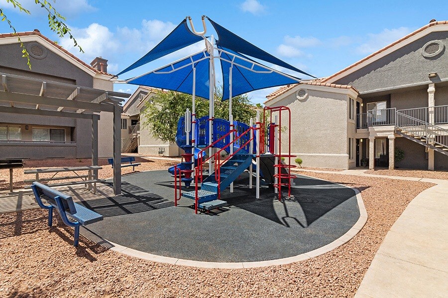 Community Playground with a Slide and Blue Canopy at Verraso Apartments in Las Vegas, NV.
