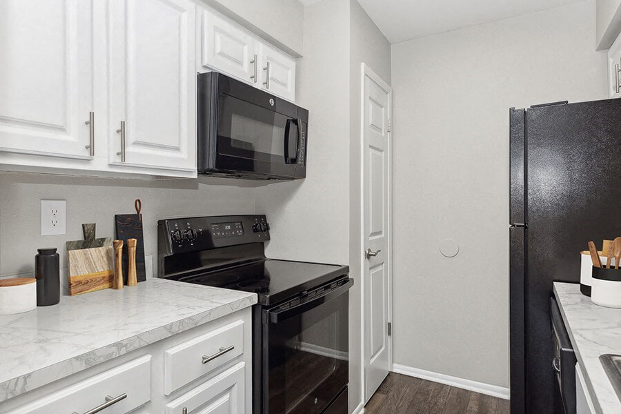 Model Kitchen with White Cabinets and Wood-Style Flooring at Grand Pavilion Apartments in Tampa, FL.