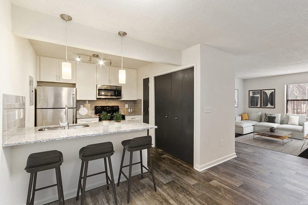 Model Kitchen with White Cabinets and Wood-Style Flooring at Grandstand Apartments in Marietta, GA.