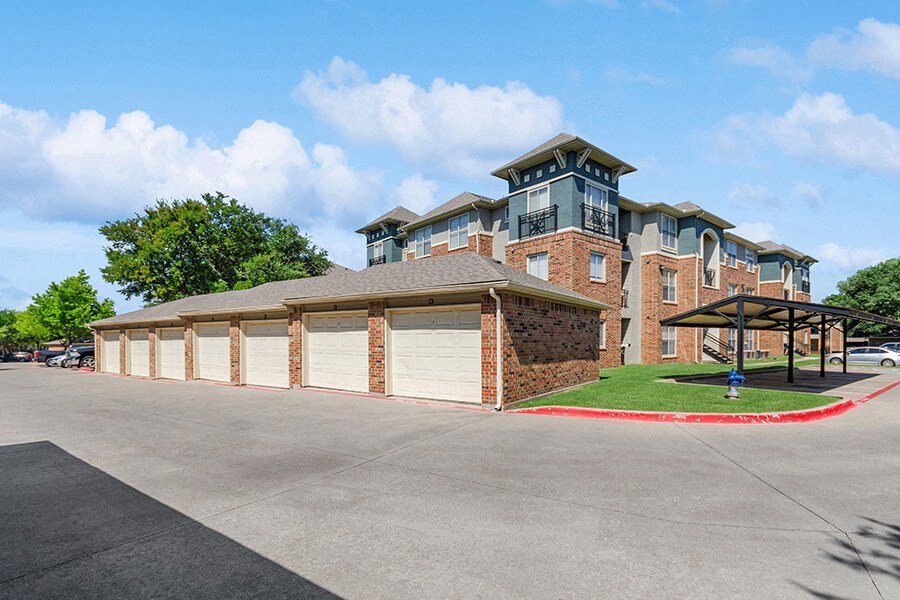 Exterior Community Building and Garages at Belmont at Duck Creek Apartments in Garland, TX.
