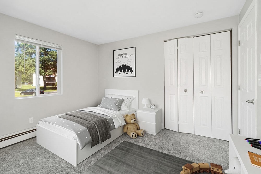 Model second bedroom with plush carpeting