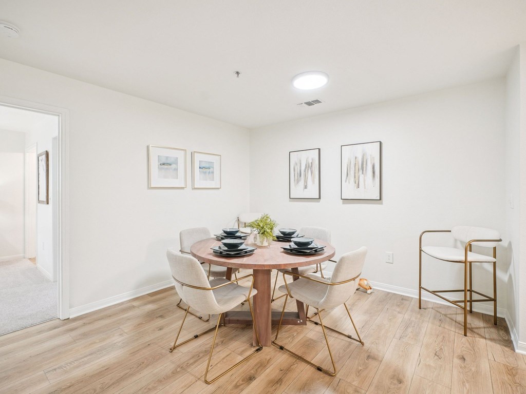 A dining room with a round table and chairs.