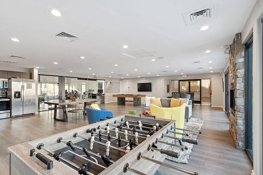 Community Clubhouse with Lounge Furniture and Pool Table Area at Liberty Creek Apartments in Aurora, CO.
