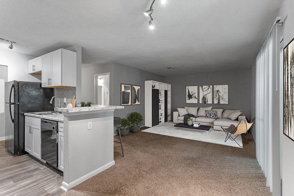 Model Living Room with Carpet and View of Kitchen at Corners at 1700 Apartments in Atlanta, GA.