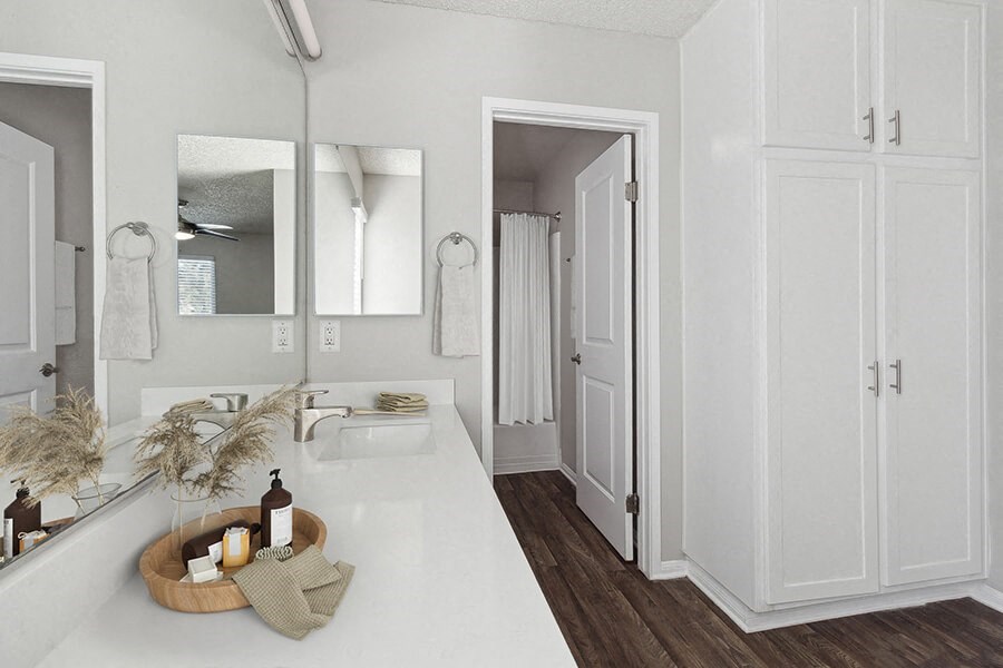 Model Bathroom with White Cabinets and Wood-Style Flooring at Colonnade at Fletcher Hills Apartments in El Cajon, CA.