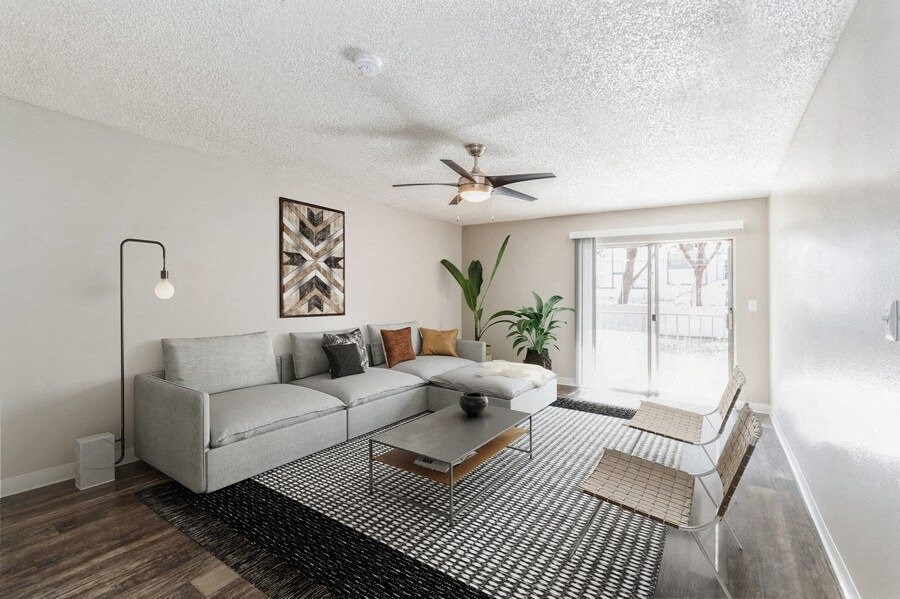 Model Living Room with Wood-Style Flooring and Sliding Glass Door at Indigo Park Apartments in Albuquerque, NM.