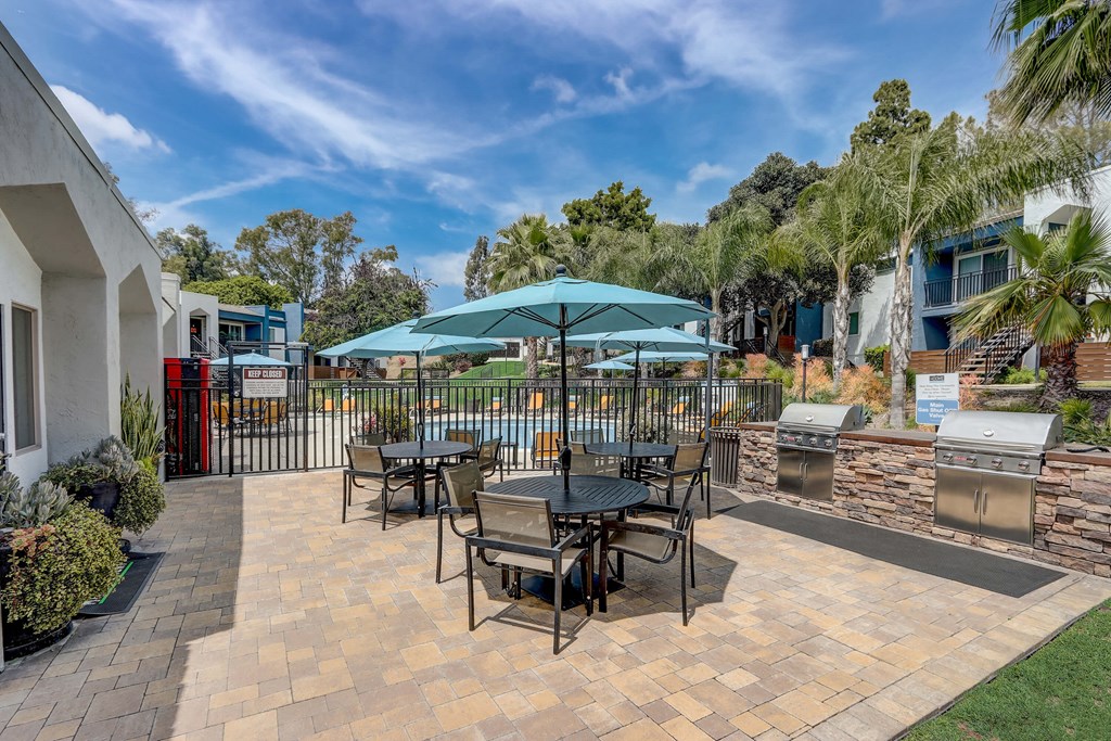 Community Picnic Tables with Umbrellas at Cove La Mesa Apartments located in La Mesa, CA.