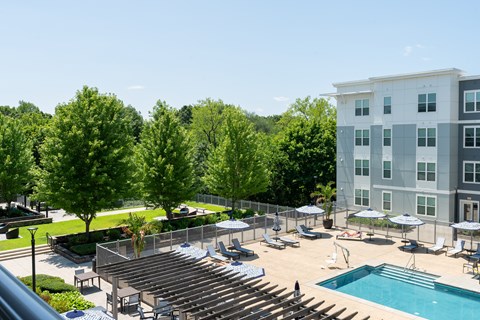 A large building with a pool and a lot of trees.
