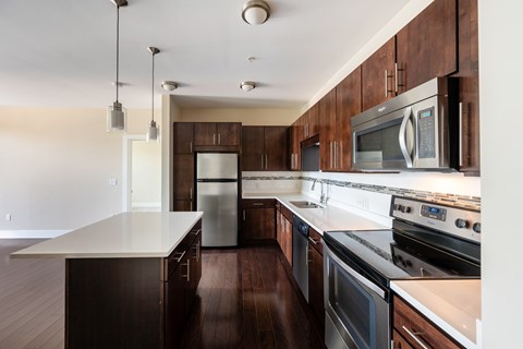 A kitchen with dark wood cabinets and stainless steel appliances.