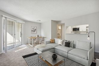 Model Living Room with Glass Sliding Door at Caribbean Breeze Apartments in Tampa, FL.