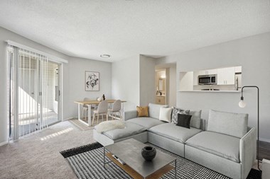Model Living Room with Glass Sliding Door at Caribbean Breeze Apartments in Tampa, FL.