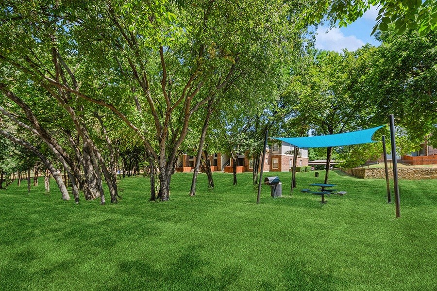 Outdoor BBQ Area with Canopy at Belmont at Duck Creek Apartments in Garland, TX.