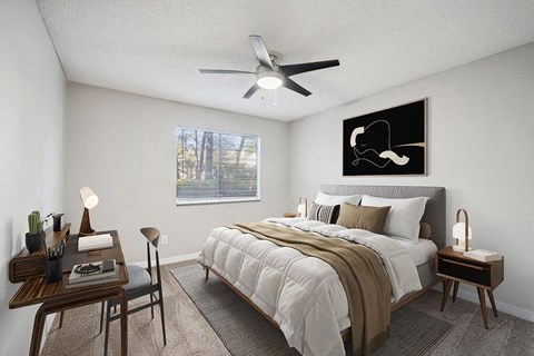 One-Bedroom Apartments in Westside Jacksonville, FL - Westland Park - A Bedroom Features Matching Nightstands With Lamps, A Desk By The Window, Neutral Tones, And A Ceiling Fan.