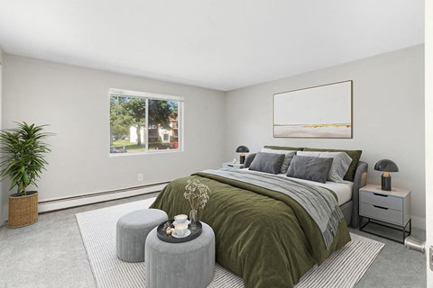 1-Bedroom Apartments in Marshfield, MA - Village At Marshfield - Bright Bedroom With Plush Carpet, Large Window, Neutral Walls, And Cozy Bed With Nightstands And Modern Lamps.