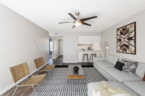 Model Living Room with Wood-Style Flooring and Kitchen View at Indigo Park Apartments in Albuquerque, NM.