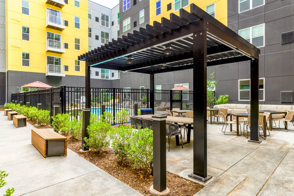 a patio with tables and chairs and a pergola