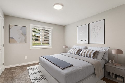 2-Bedroom Apartments in Marietta, GA - The Park on Windy Hill - A Bedroom Features Striped Pillows, Matching Nightstands With Lamps, Framed Wall Art, And A Window With White Blinds.