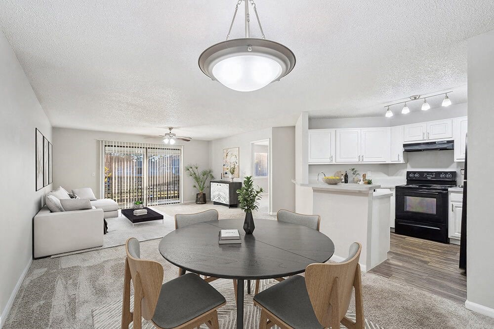 Model Dining Room with Carpet and View of Kitchen and Living Room at Westland Park Apartments in Jacksonville, FL.