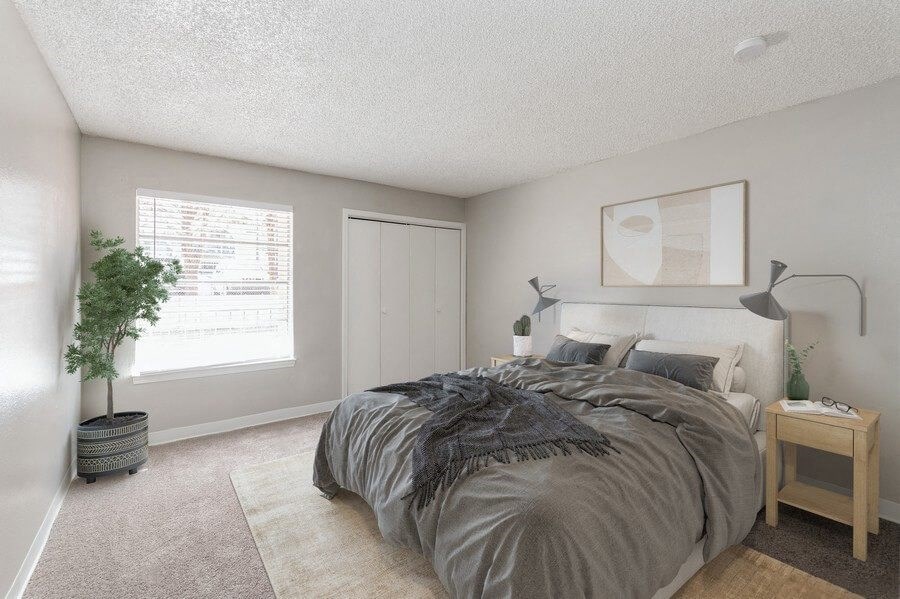 Model Bedroom with Carpet and Window View at Indigo Park Apartments in Albuquerque, NM.