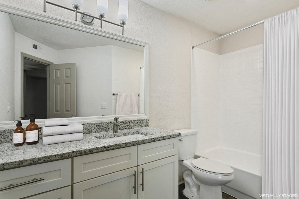 Model bathroom with a sink, toilet, and bathtub at Retreat at Crosstown Apartments