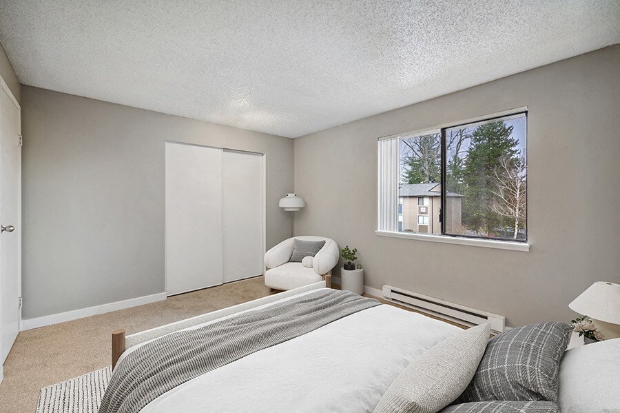 Model Bedroom with Carpet and Window View at Grammercy Apartments located in Renton, WA.