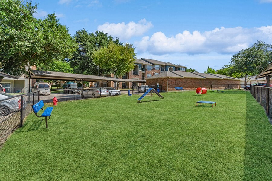 Community Dog Park with Agility Equipment at Belmont at Duck Creek Apartments in Garland, TX.