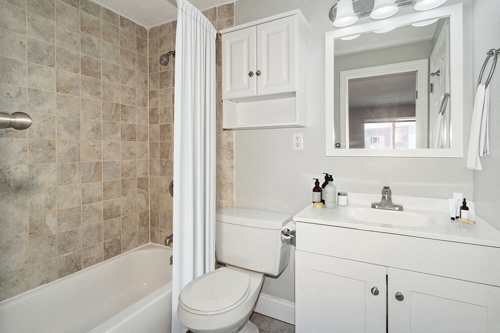 Model bathroom with a toilet, sink, and bathtub