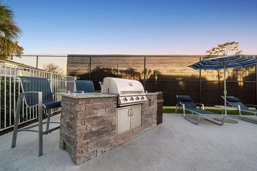 Outdoor BBQ Area with Lounge Furniture at Arbors at Orange Park Apartments located in Orange Park, FL.