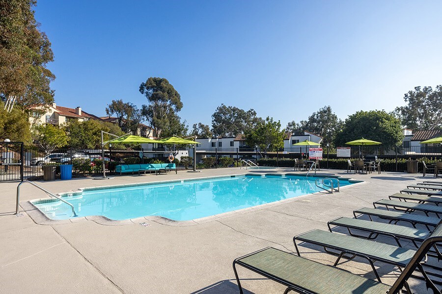 Community Swimming Pool with Pool Furniture at Santa Fe Ranch Apartments located in Carlsbad, CA.