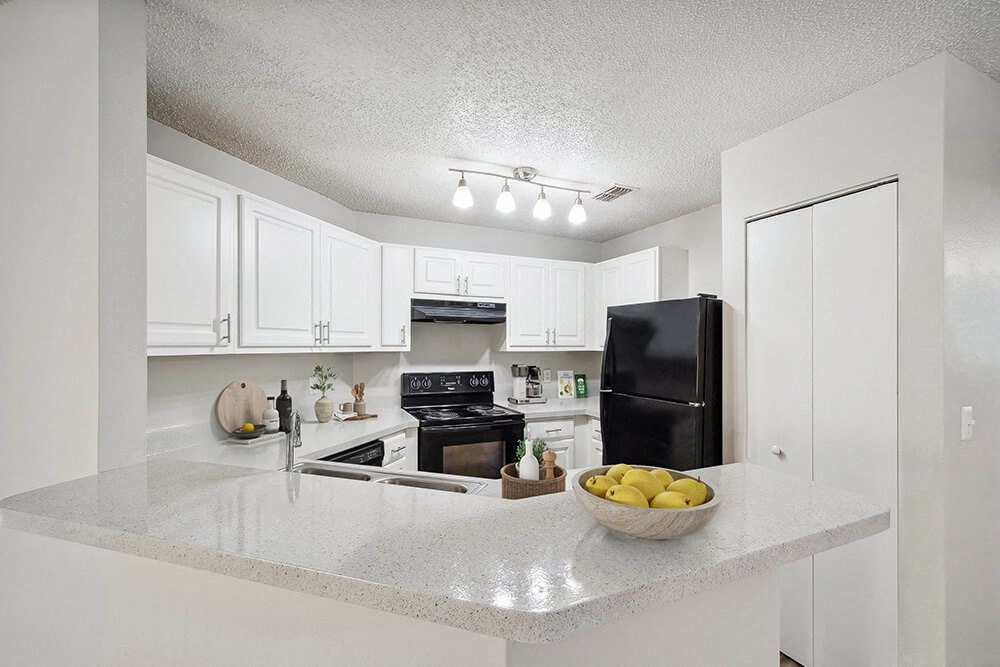 Model Kitchen with White Cabinets and Wood-Style Flooring at Westland Park Apartments in Jacksonville, FL.
